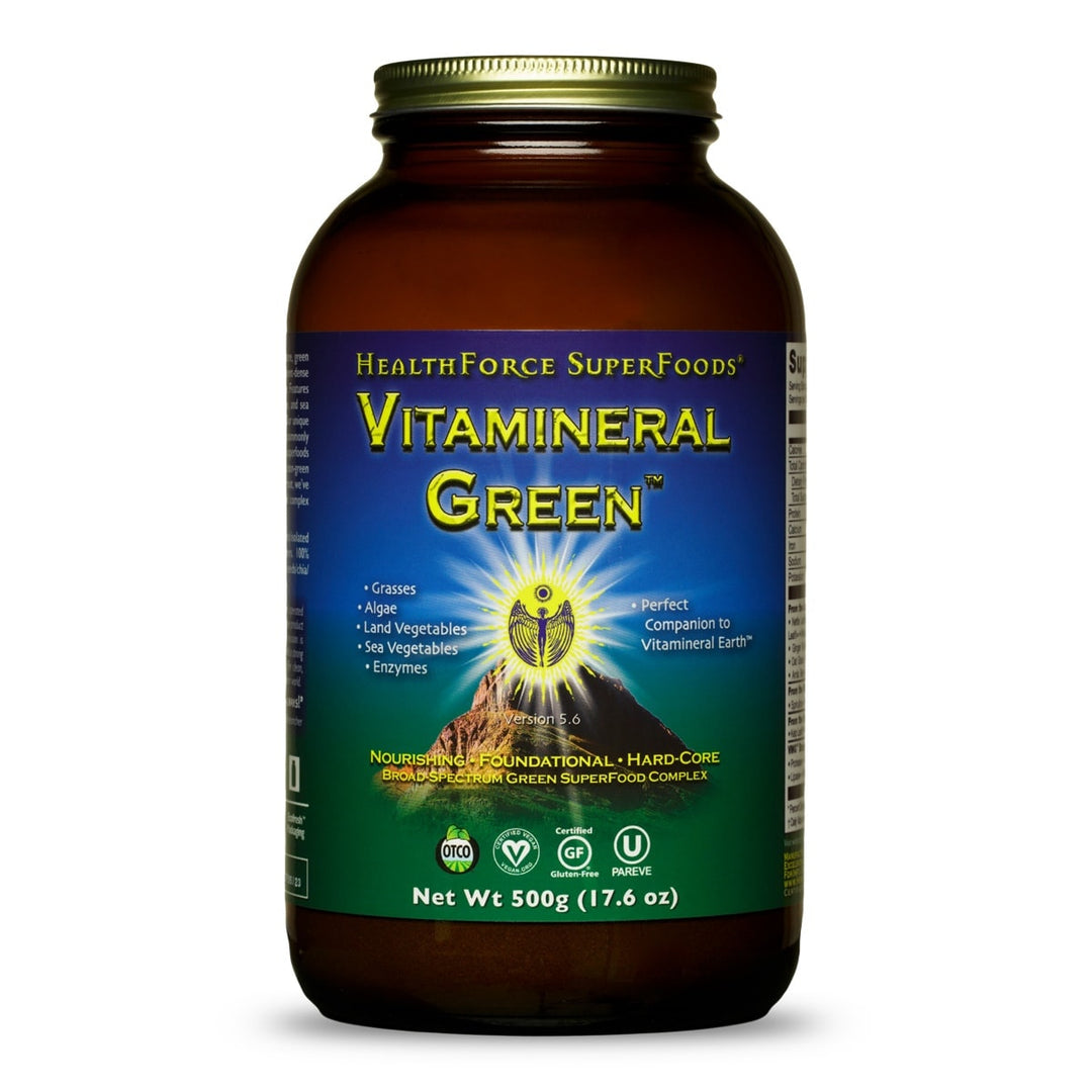 A 500g bottle of Health Force SuperFoods Vitamineral Green dietary supplement, featuring an amber brown bottle, a gold cap, and a blue and green label with a central mountain graphic.